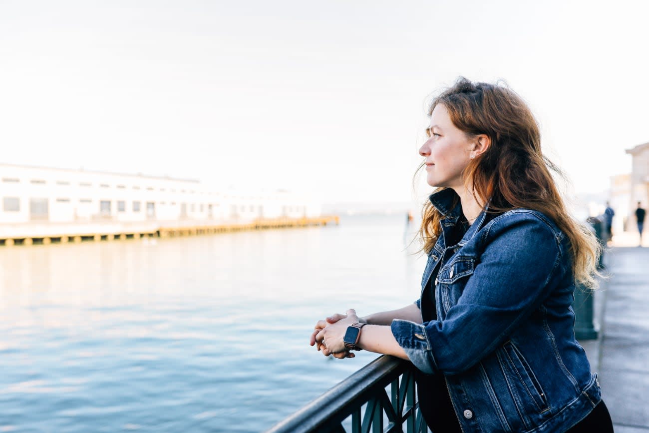 Photo of Kathy Korevec standing at a pier and looking over the fence.