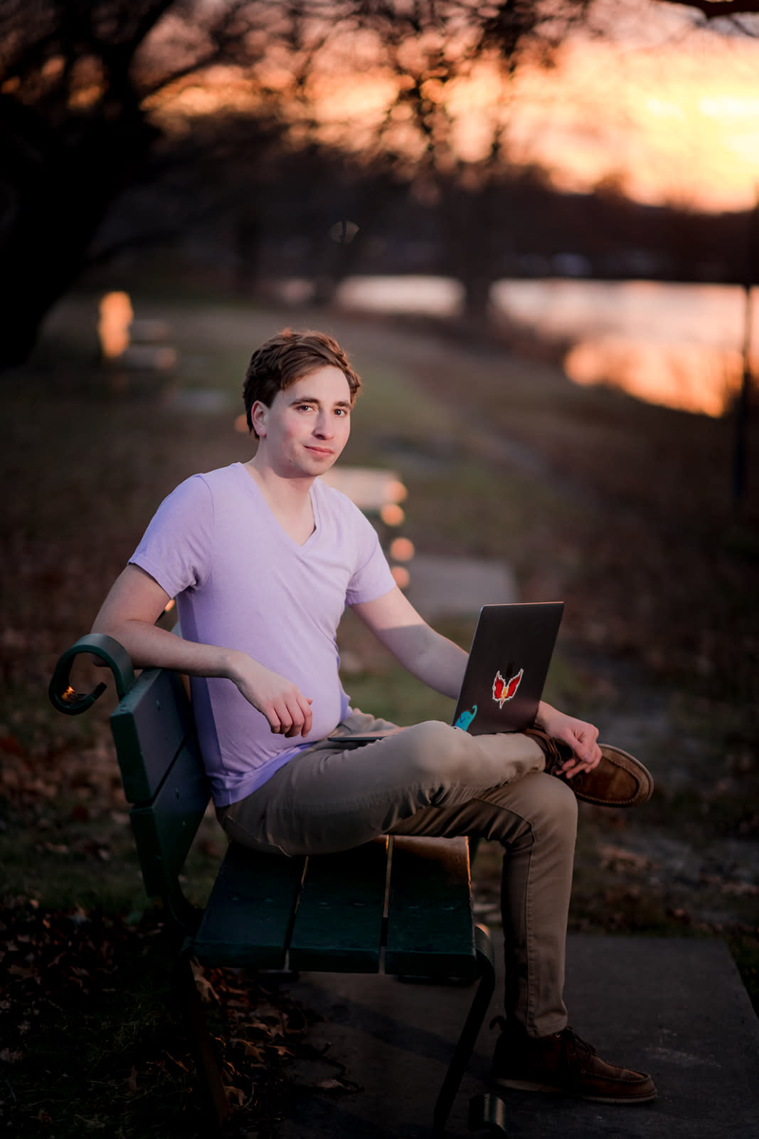 Author Jonathan sitting outside next to the water with his laptop 