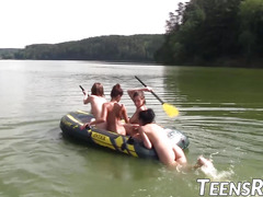 Group of naughty teens is having fun while swimming outdoor